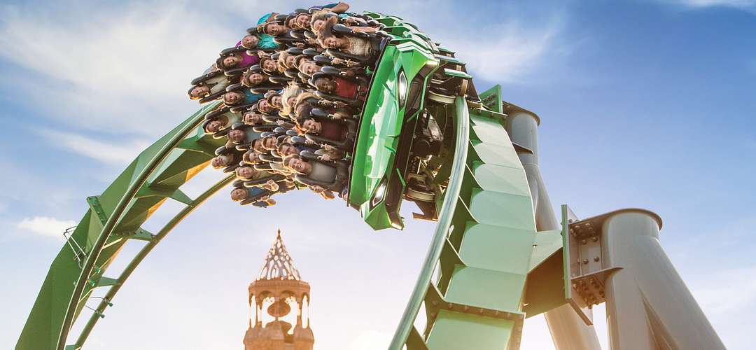 The Incredible Hulk Coaster® la montaña rusa The Incredible Hulk Coaster® voltendo con los pasajeros gritando de la emoción