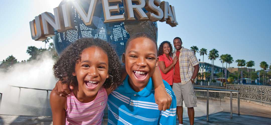Universal Orlando Resort A family playing and posing in front of the Universal Orlando globe.