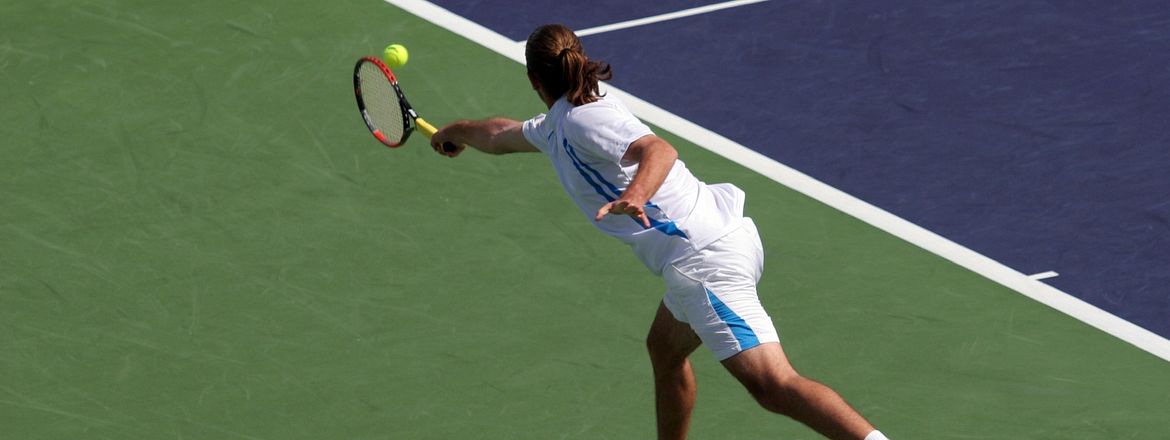 tennis backhand Tennis player lunging after a ball with a backhand