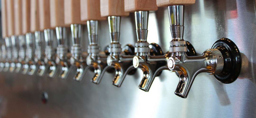Beer Taps Closeup of over a dozen beer taps perfectly aligned behind the bar