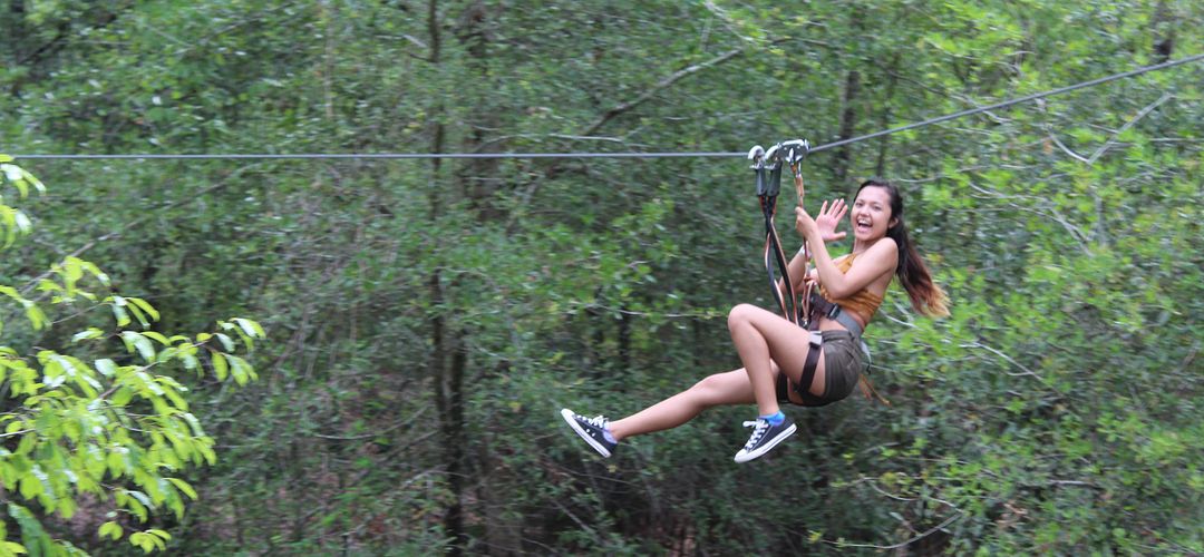 Orlando Tree Trek Adventure Park A girl ziplines through trees in Orlando