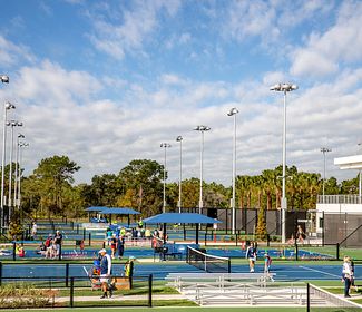 USTA National Campus hard courts A sunny day at the USTA national campus with players and spectators on the courts