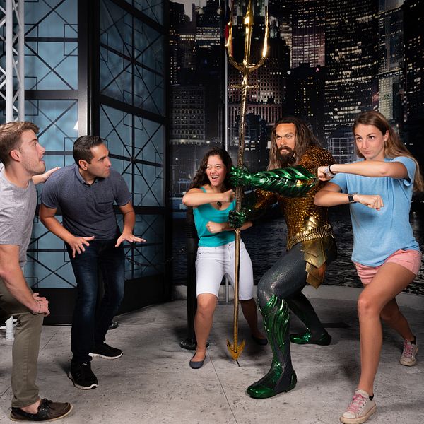 Guests pose with a wax figure resembling Pitbull at