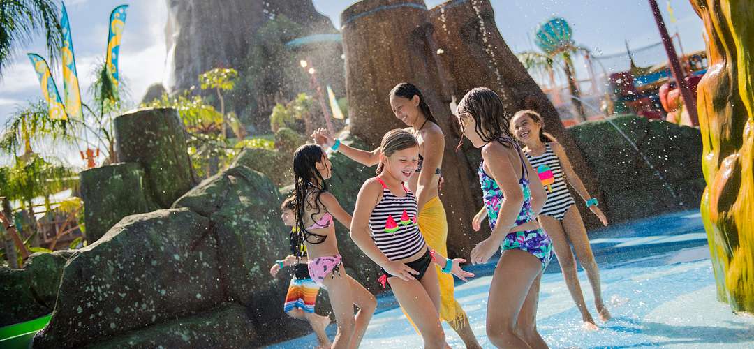 Volcano Bay's Tot Tiki Reef Children gathered around in a pool with the volcano in the background