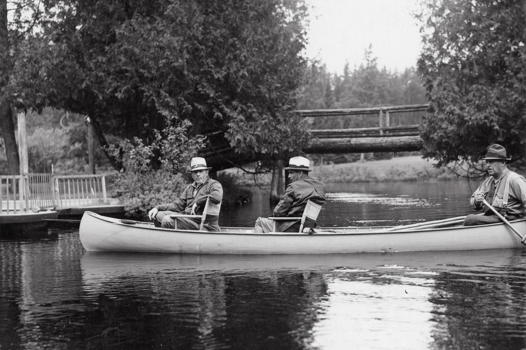 Historic photo of three men in a canoe on the Brule River