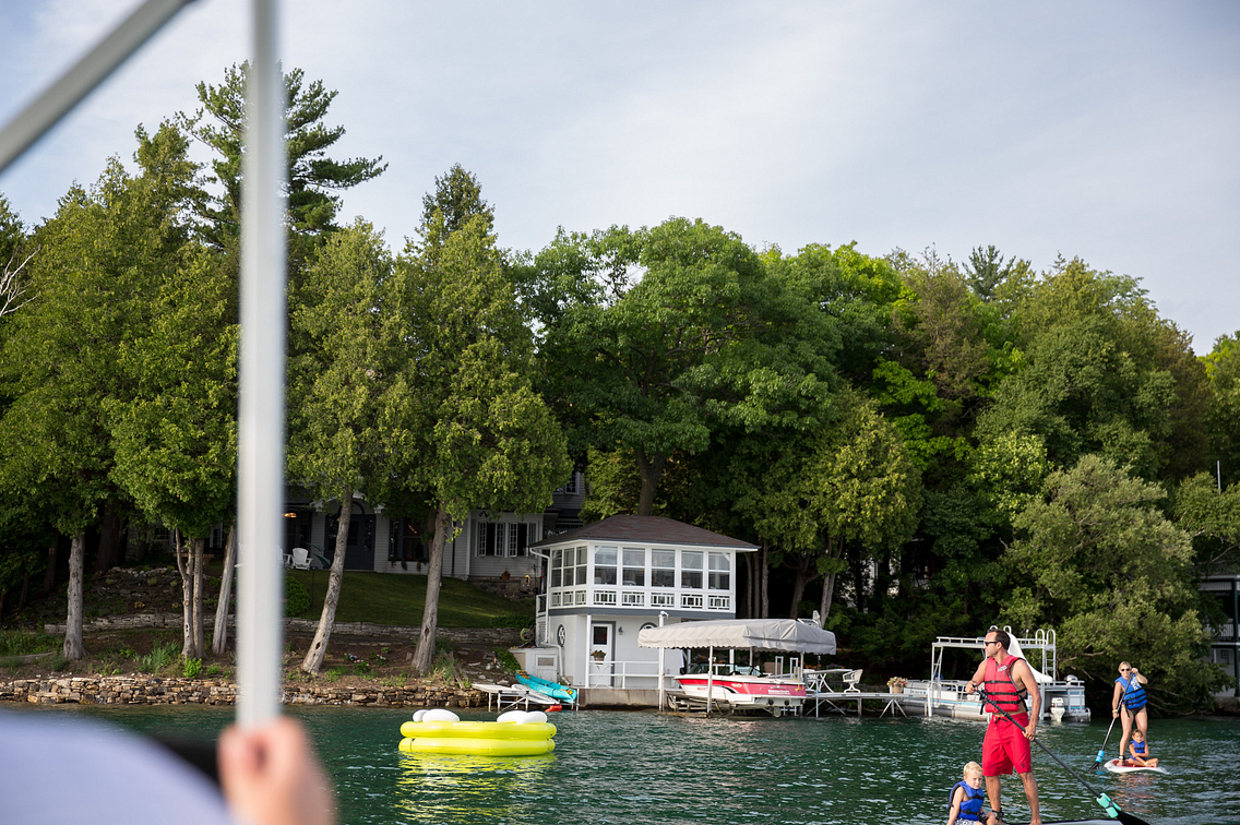 People on waterboards in a busy lake setting