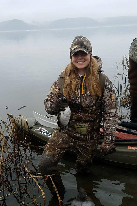 Young woman hunter holding a duck she shot
