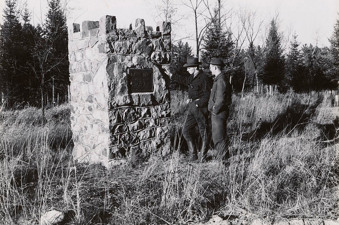 Vintage black and white photo of two men inspecting a marker at Ojibwa Roadside Park