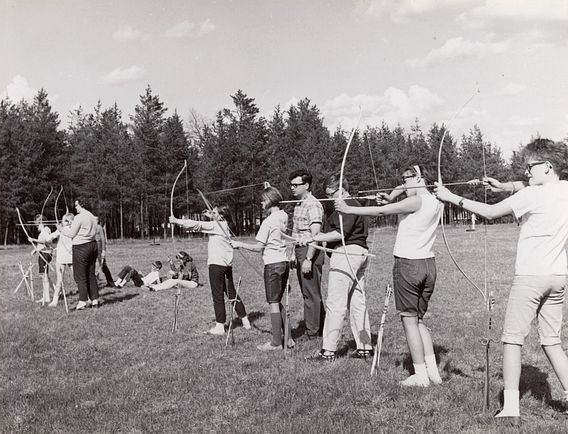 historic photo of teenagers practicing archery skills