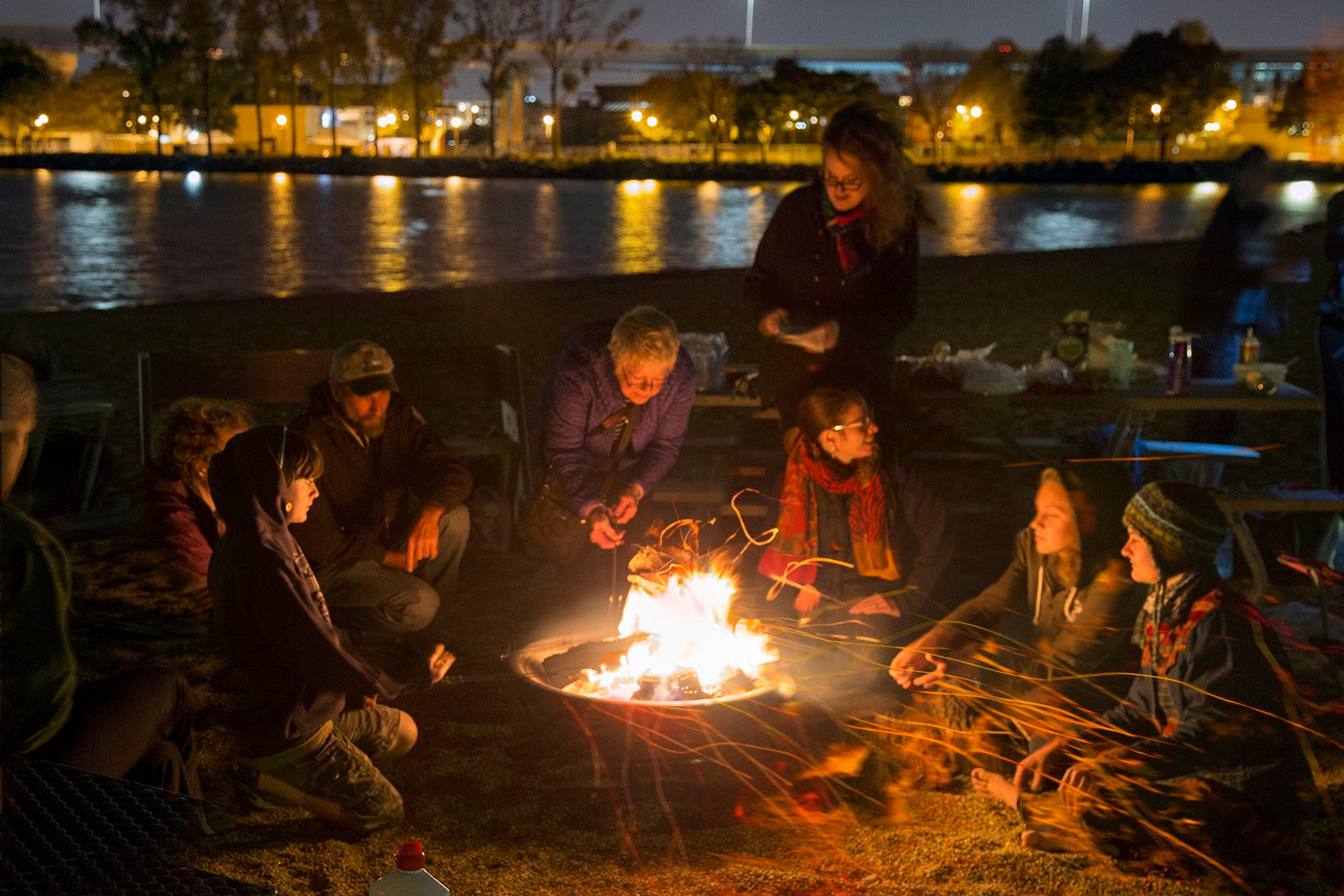 People sitting near nighttime bonfire at Lakeshore State Park