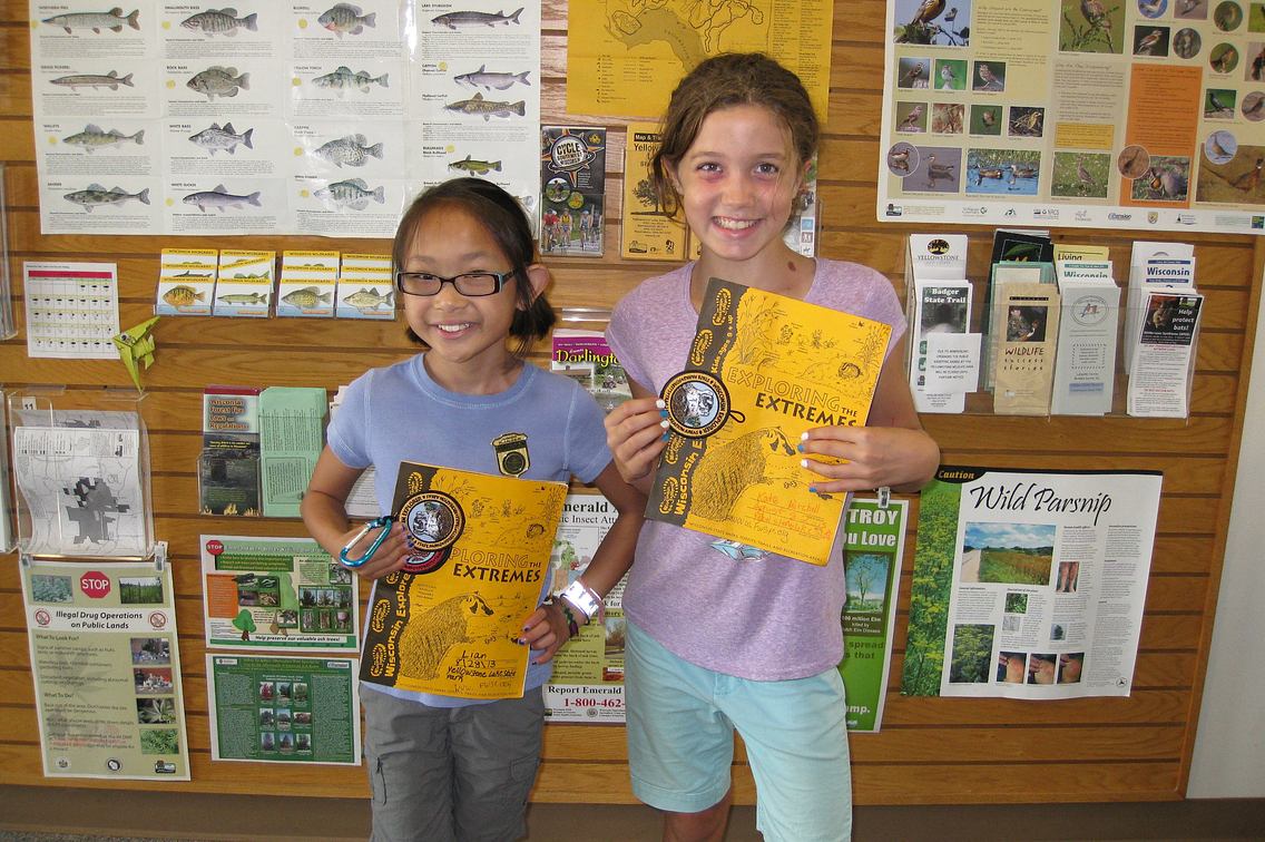 Two young girls holding Wisconsin Explorer program books