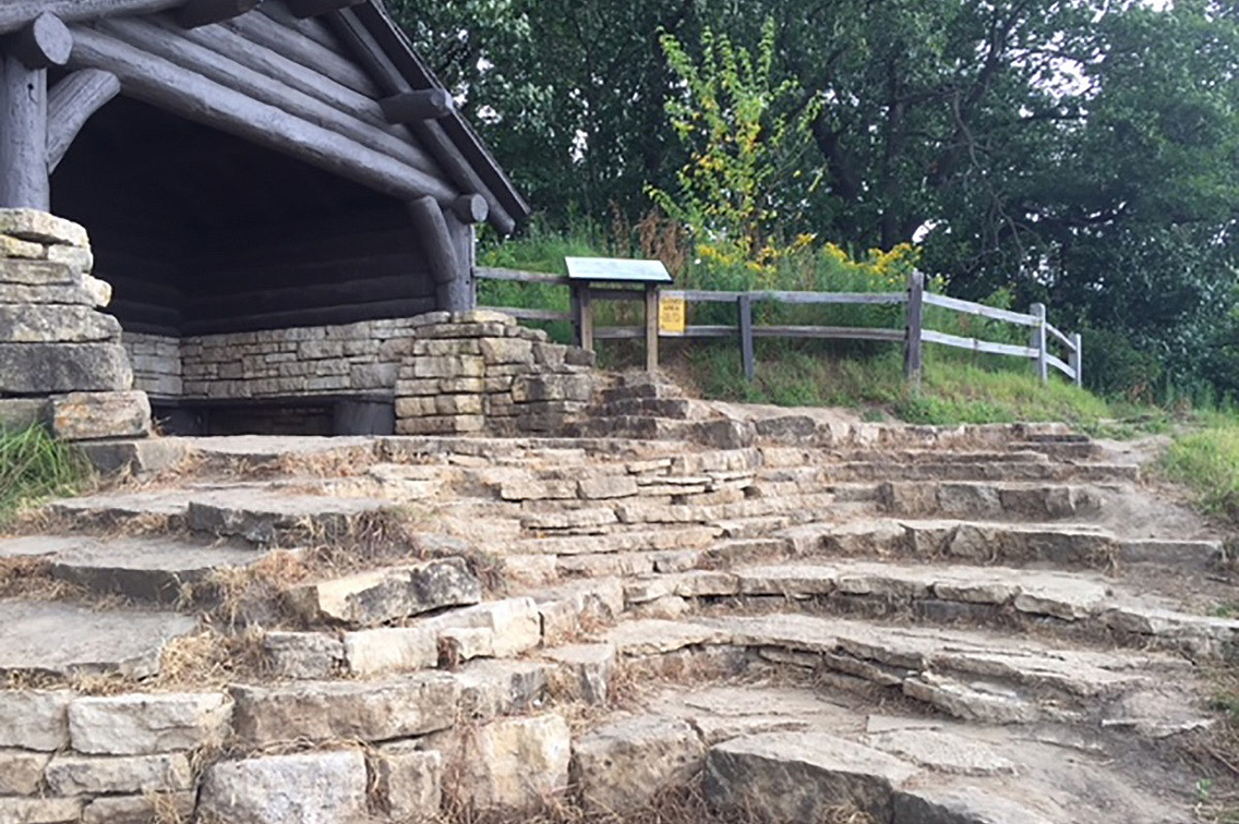Steps in rock with a wooden structure on left and trial on right