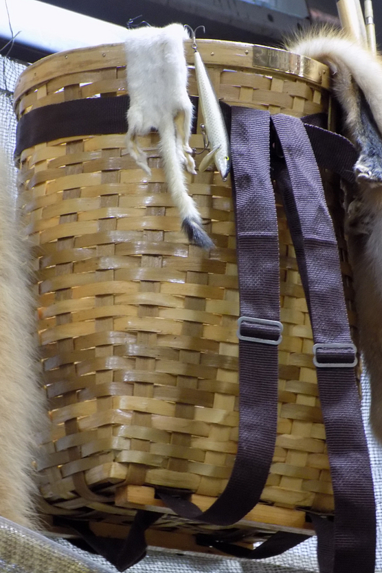 Handmade basket containing furs hanging on a wall