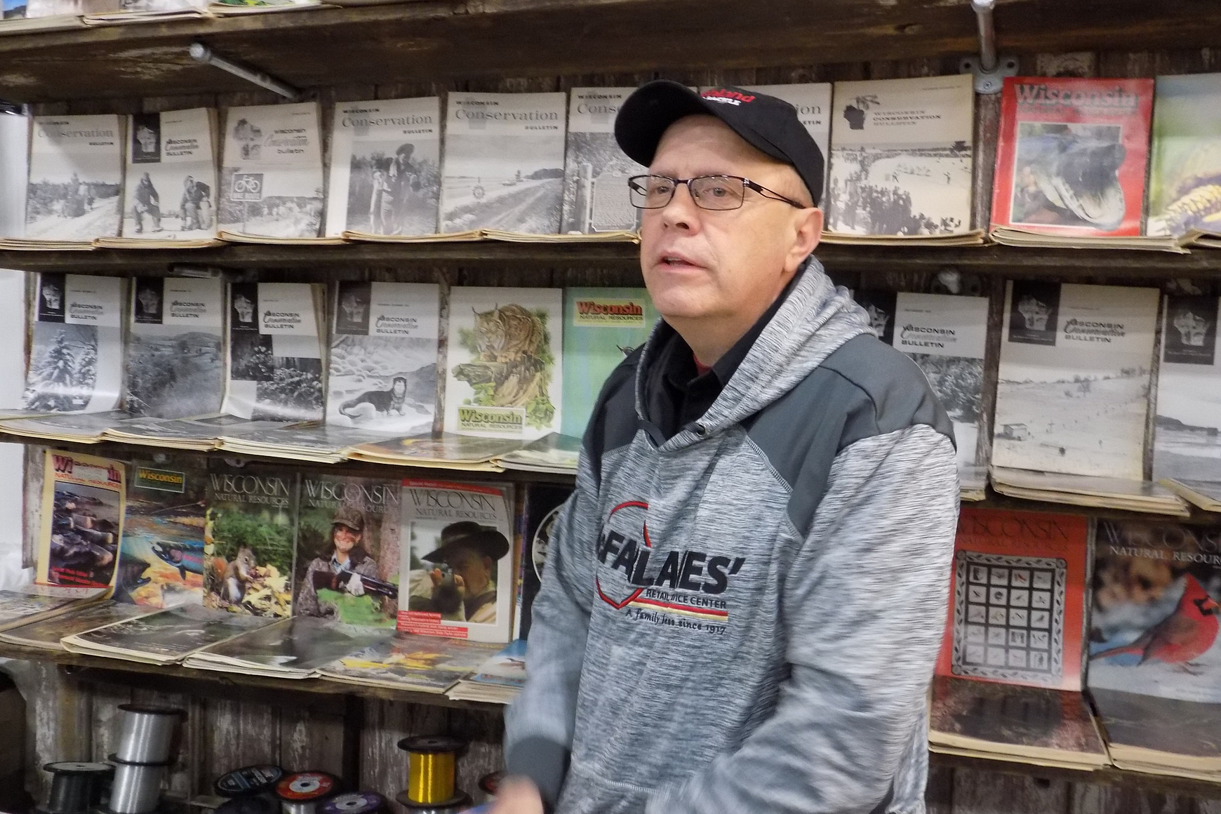 Man sitting in front of display of magazines