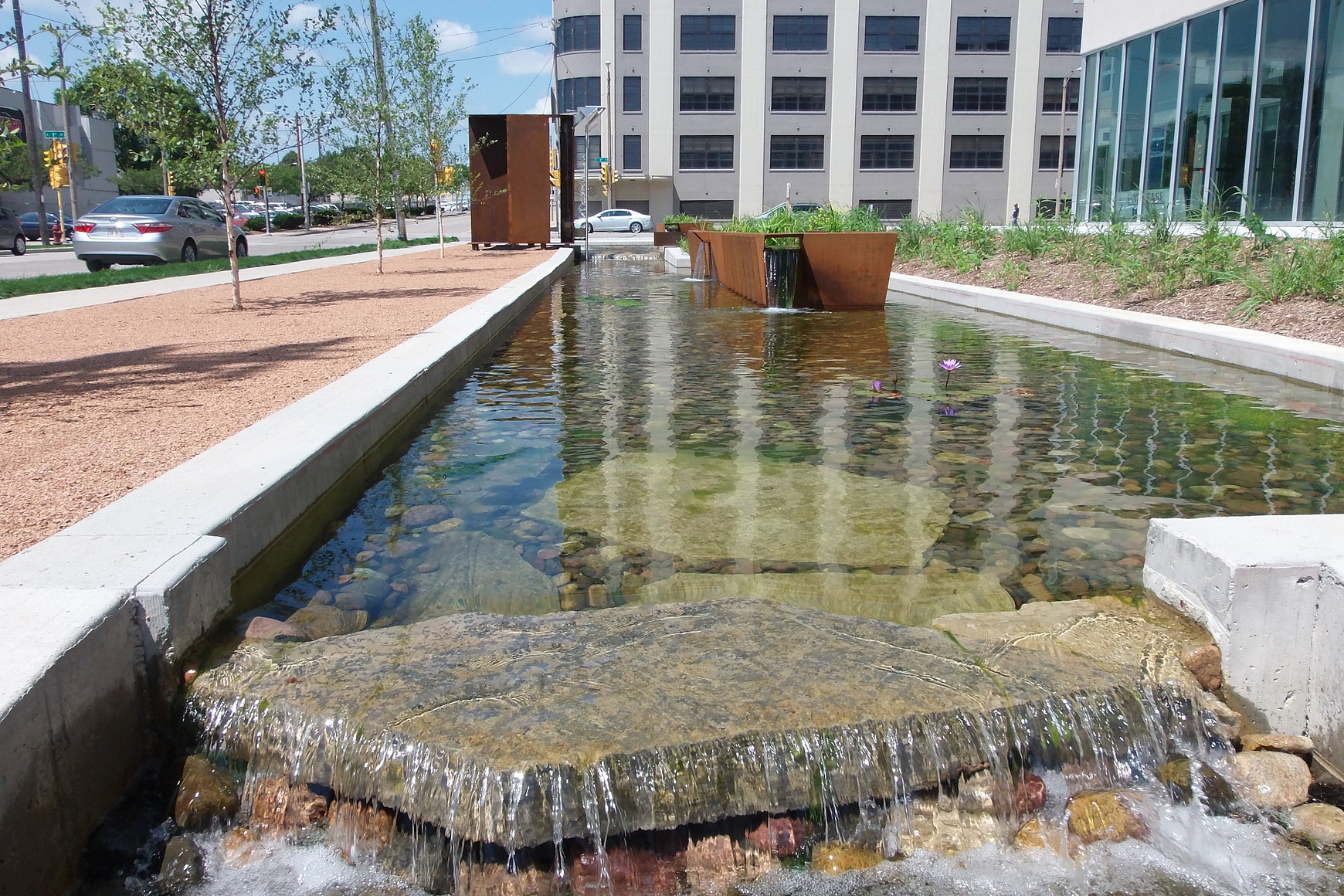 Water spilling over a rock in an urban landscaped setting