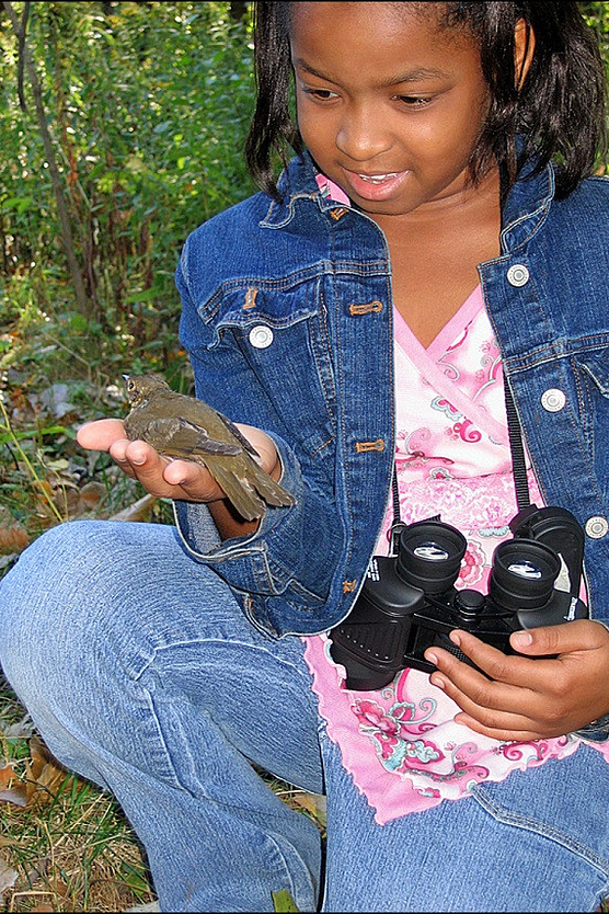Photo of young girl with a bird in her hand