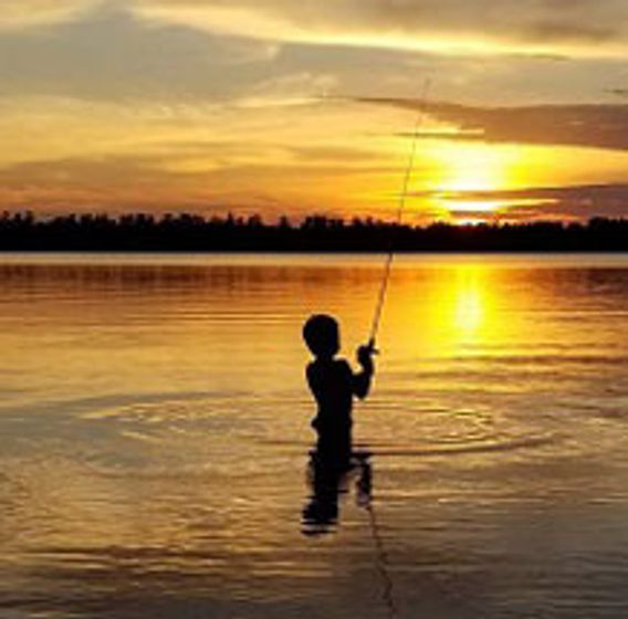 boy fishing at sunset