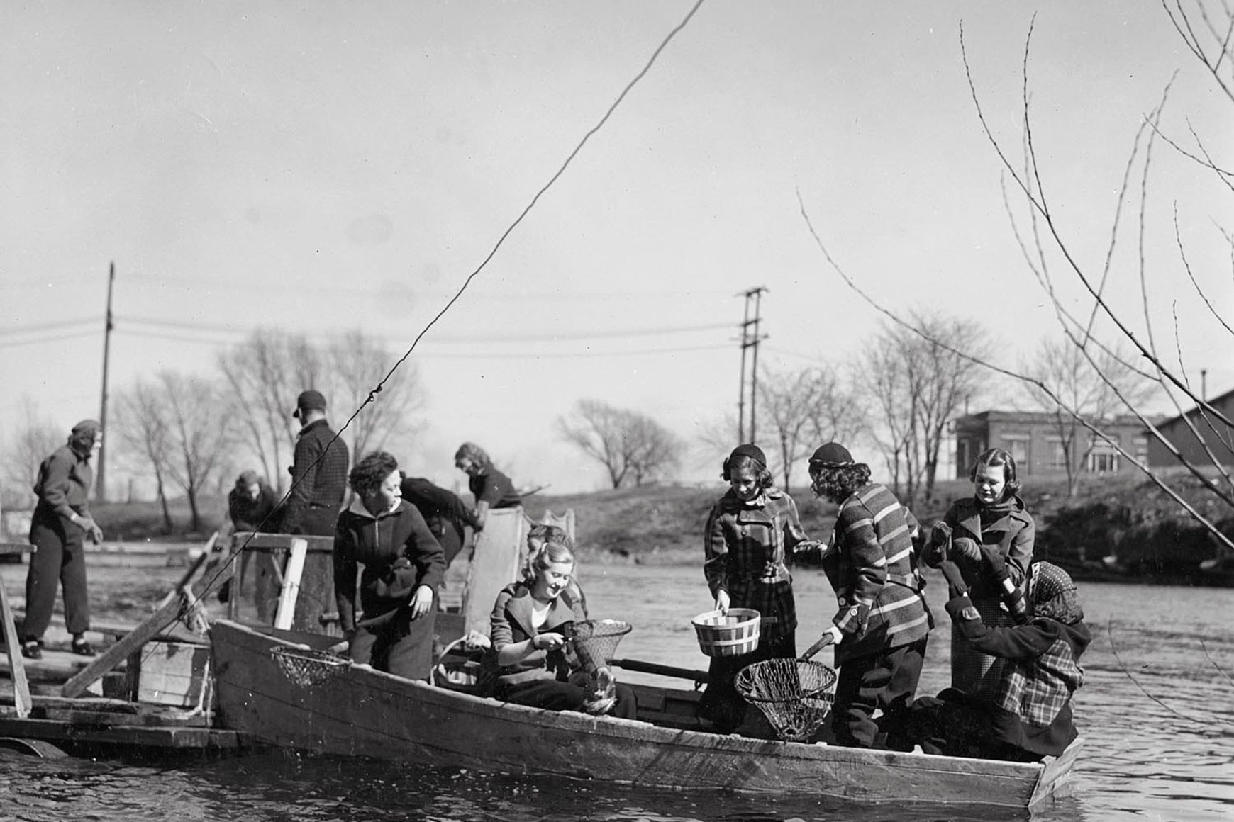 Historic photo of women dipping for smelt from boat