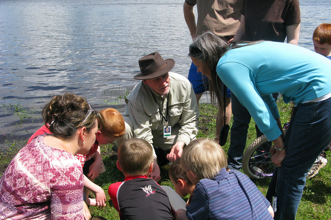 Man kneeling among group of young students