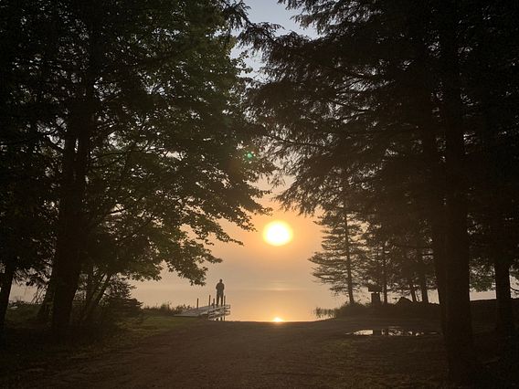 person fishing at sunrise