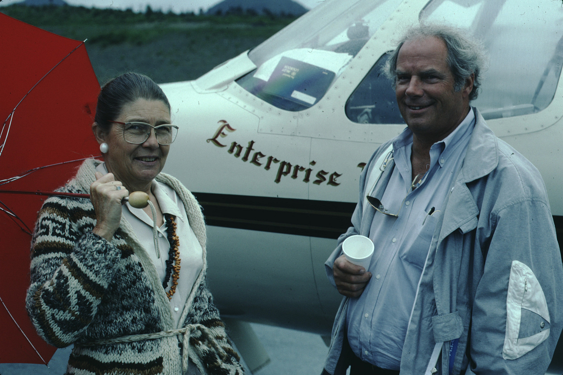 Couple standing in front of plane