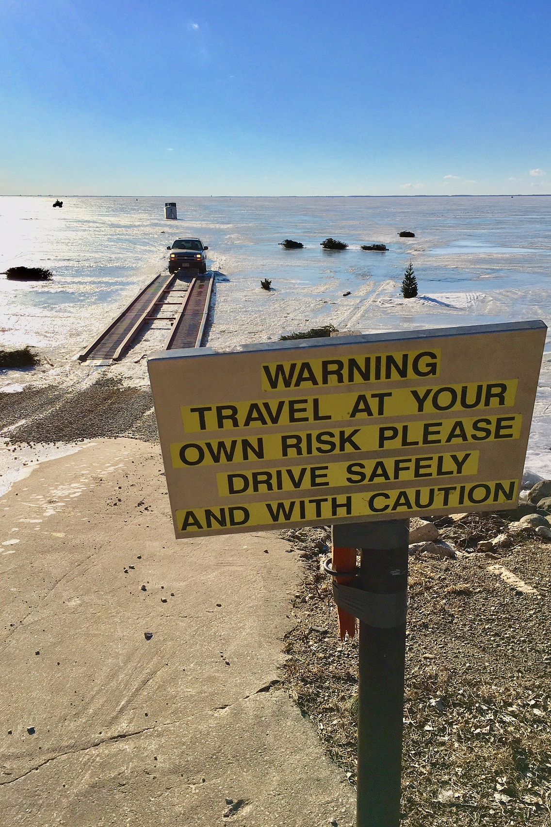 Ice safety warning sign on frozen lake