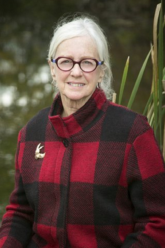 Woman with white hair, glasses and red plaid jacket