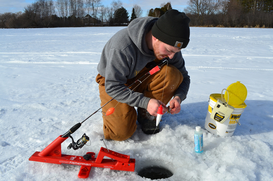 Angler fixing his line while ice fishing