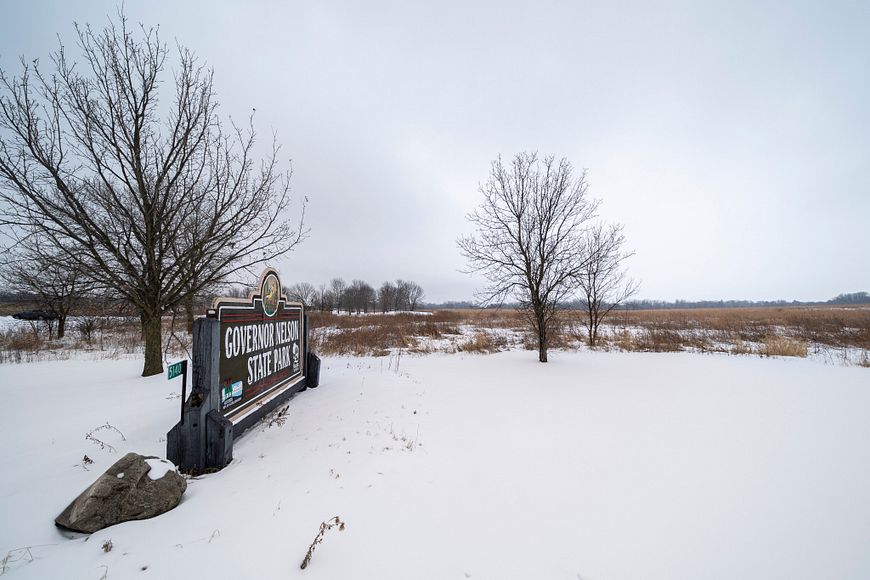 snowy scene and entry sign at Governor Nelson State Park