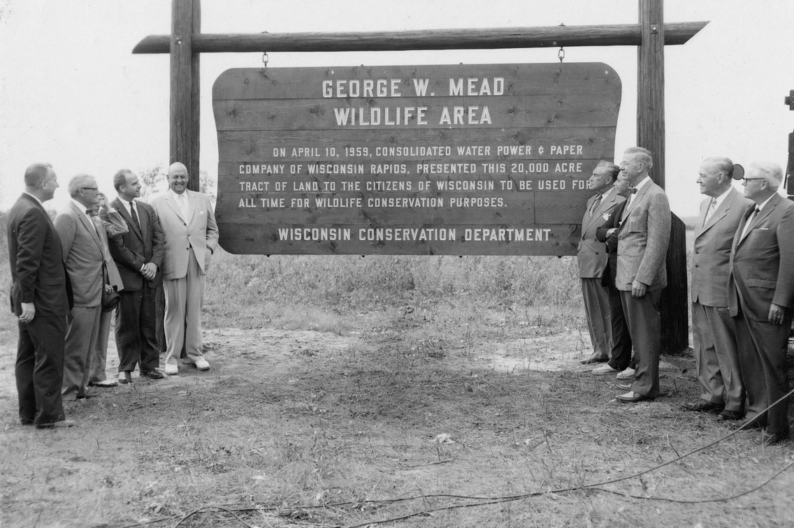 Historic black and white photo showing group of men gathered around large sign that reads George W. Mead Wildlife Area