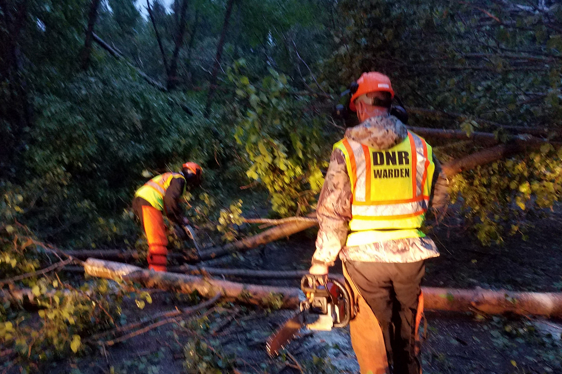 Photo of DNR personnel in reflective vests helping clear brush