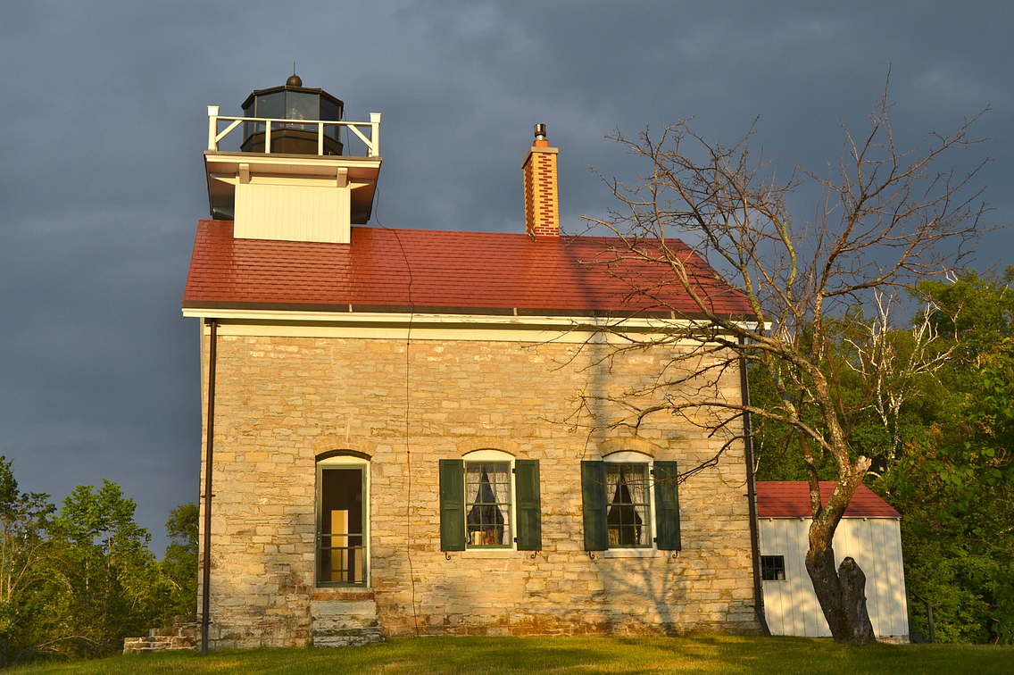 Cream-colored brick building with red roof and lighthouse on roof