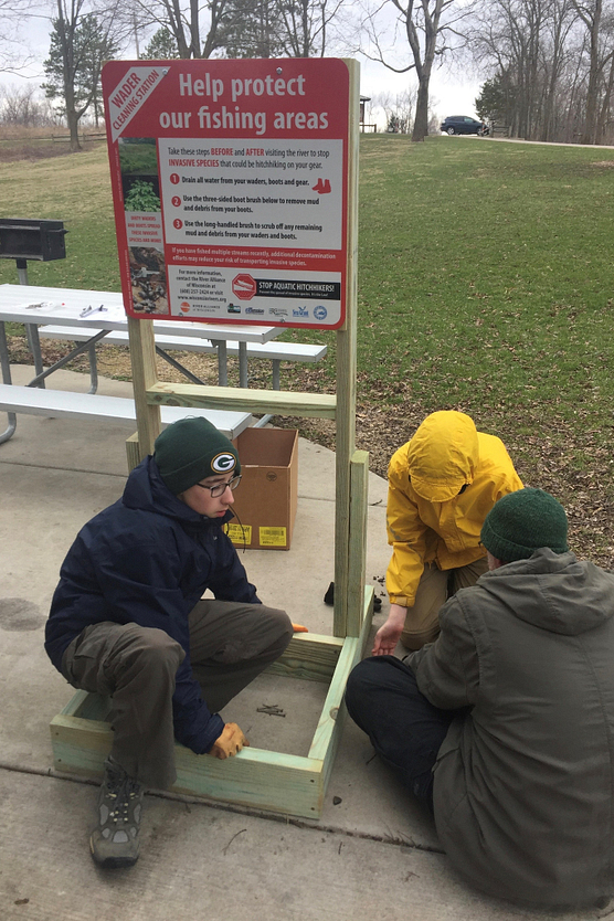 Three young boys work on constructing a Wader Wash Station