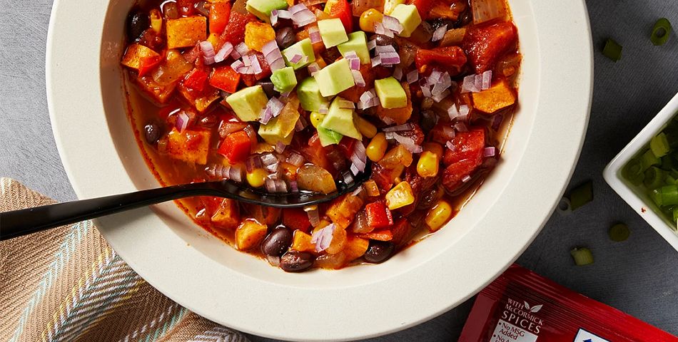 Vegetarian Chili served in a wide white soup bowl and package of McCormick® Original Chili Seasoning next to it