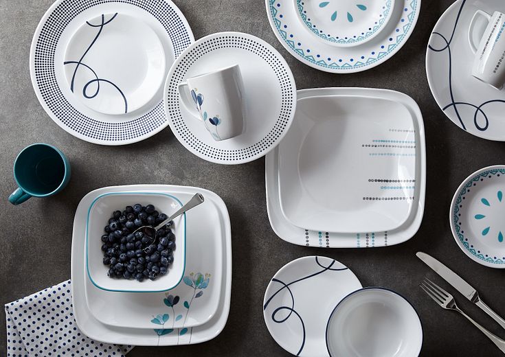 a showing of a variety of blue colored patterns of corelle plates, bowls and mugs