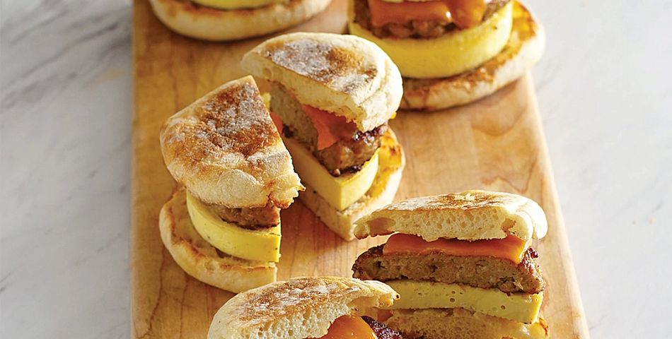 Sausage and Egg Sandwiches cut in halves on a cutting board
