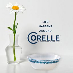 Azure Medallion 18-ounce Cereal Bowl with vase with daisy inside next to it and text "life happens around Corelle"