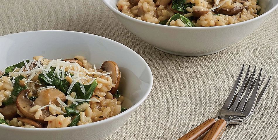 Mushroom and Spinach Risotto in white bowls on table 