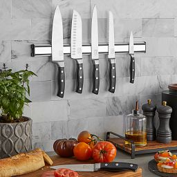 18" Stainless Steel Magnetic Knife Storage Bar shown with knives attached to the bar on the wall